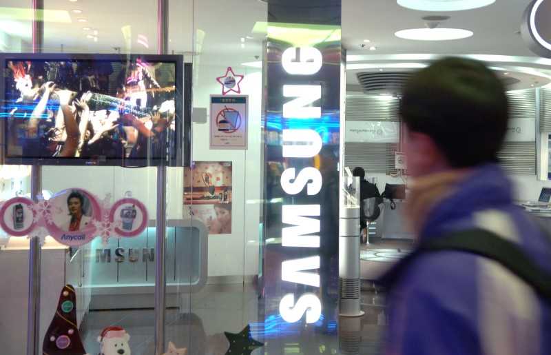 En man står framför en Samsung-skylt.