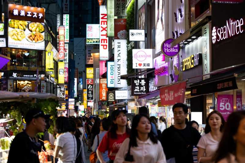Gående på en gata med neonskyltar i Seoulm Sydkorea