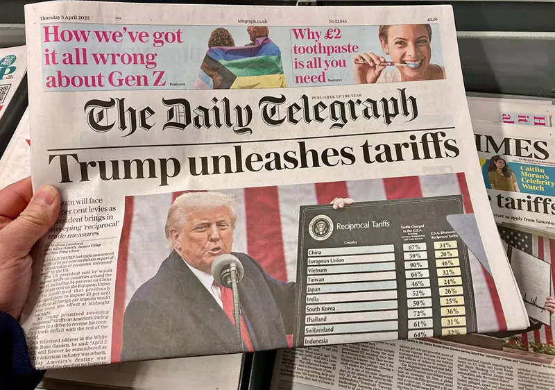 Framsidan av tidningen The Daily Telegraph med rubriken "Trump unleashes tariffs". Bilden visar Donald Trump som håller ett tal vid en mikrofon, framför en amerikansk flagga. Bredvid honom visas en tavla med titeln "Reciprocal Tariffs" och en lista över olika länder tillsammans med procentsatser. Tidningen är daterad torsdag 3 april 2025.